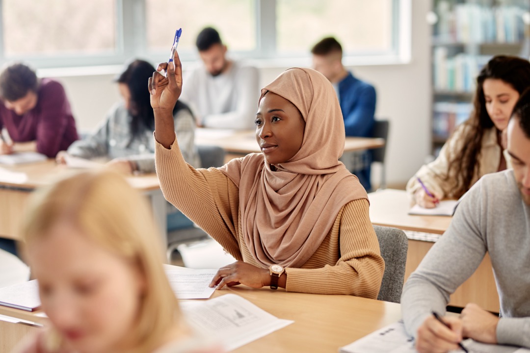 Student raising their hands in class